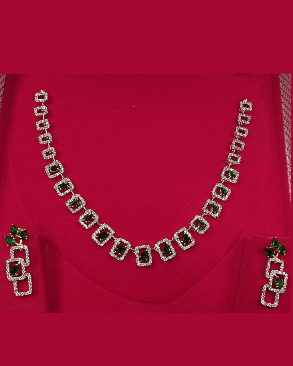 Necklace set with green gemstones on a red fabric background