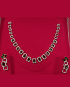 Necklace set with green gemstones on a red fabric background